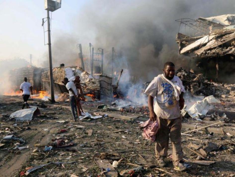 Civilians walk at the scene of an explosion in KM4 street in the Hodan district of Mogadishu, Somalia October 14, 2017