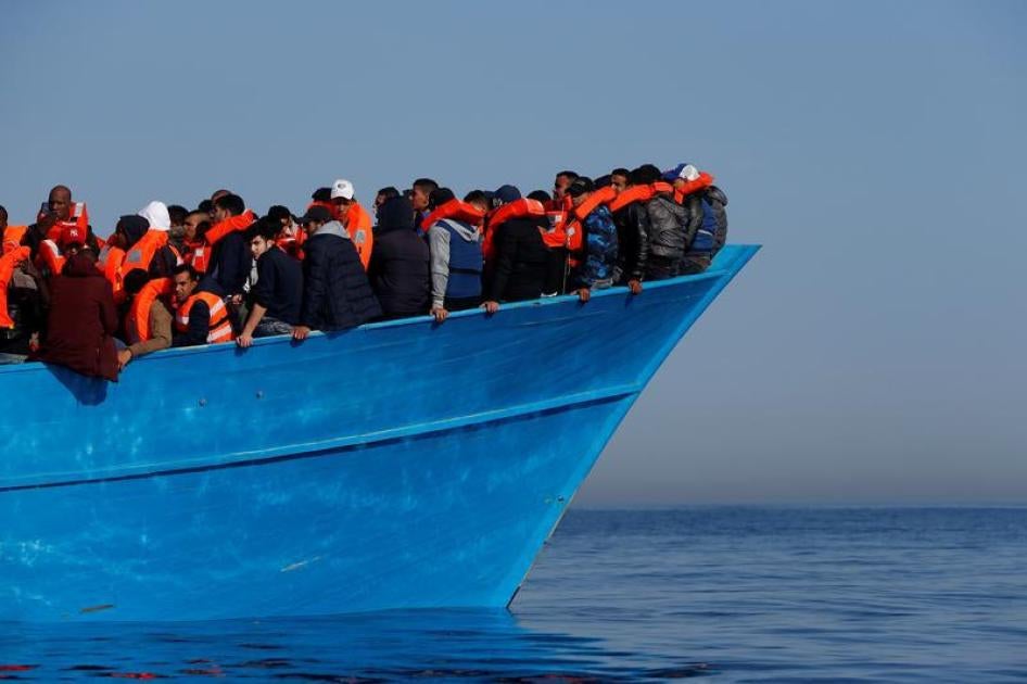 Migrants on a wooden boat await rescue by the Malta-based NGO Migrant Offshore Aid Station in the central Mediterranean in international waters off the coast of Sabbath, Libya on April 15, 2017. © 2017 Reuters