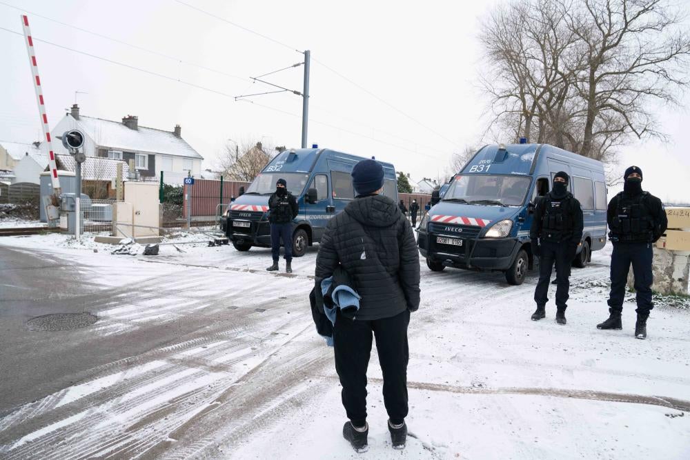 A teen stands in front of a group of policemen 
