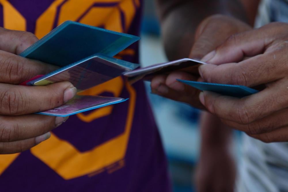 A boatswain hands out pink cards to a falling netter crew prior to a PIPO inspection in Laem Ngop, Trat, November 9, 2016. Employers frequently retain, and sometimes seize, identity documents belonging to fishers. 
