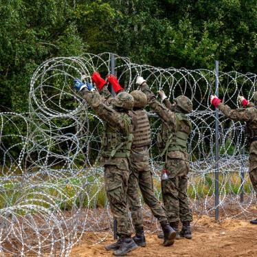 Polish soldiers build a fence with concertina wire at the border with Belarus in Krynki, Poland, on August 27, 2021.