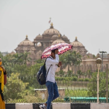 A man shields himself from the sun with an umbrella
