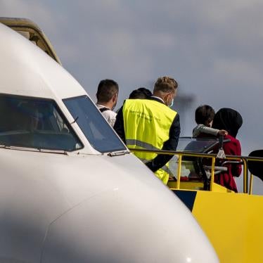 An Afghan woman carries a child as she disembarks at Copenhagen Airport.