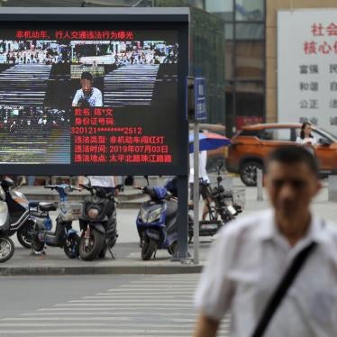 Pedestrians walk across a crossroad as a big electronic screen supported by face-recognition system shows the image of a jaywalker at the intersection in Nanjing city, east China's Jiangsu province, July 4, 2019. 