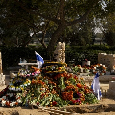 A mourner at the grave of hostages Shiri Bibas, Kfir Bibas and Ariel Bibas after their funeral on February 26, 2025, in Tzohar, Israel.
