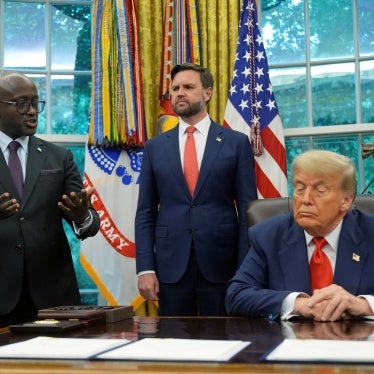 President Trump sitting in the Oval Office surrounded by aides 