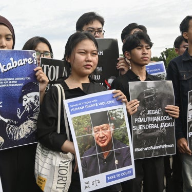 Demonstrators hold placards depicting the late Indonesian President Suharto during a rally against a government proposal to name him a “national hero”