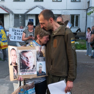 A Ukrainian serviceman released from Russian captivity during a prisoner exchange hugs a crying woman searching for her missing loved ones in Chernihiv Oblast, Ukraine, on May 23, 2025.