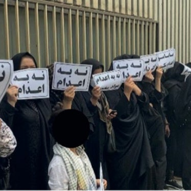 Family members of people on death row gather outside the judiciary building in Tehran, Iran, May 24, 2023, holding signs that read “no to executions.”
