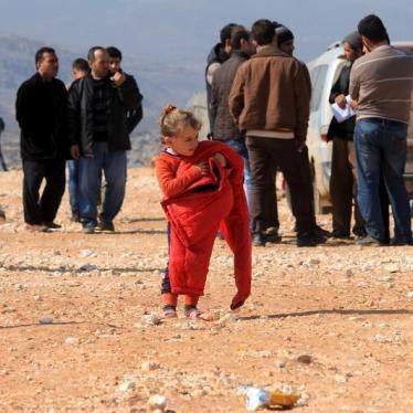 An internally displaced Syrian girl who fled from Aleppo carries a red jacket in the village of Batabo, Syria on February 14, 2016. 