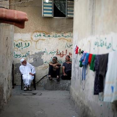 Palestinians sit outside their houses to escape from the heat during a power cut in the Shati refugee camp, Gaza City. 
