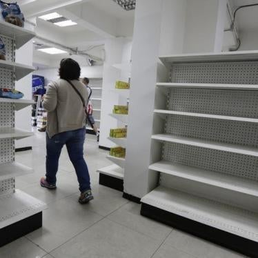 A woman walks past empty shelves at a drugstore in Caracas, February 23, 2016.