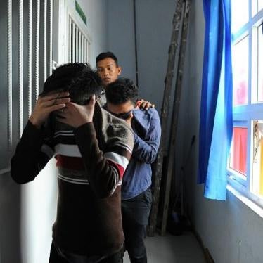 Two Indonesian men walk into a cell prior to their trials at a shariah court in Banda Aceh on May 17, 2017. 