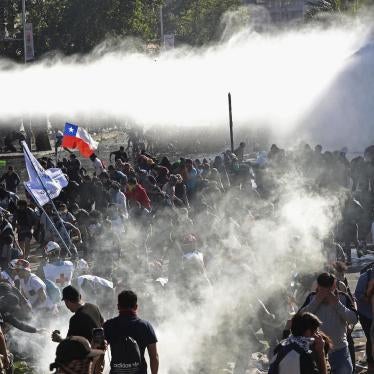 Demonstrators run from police launching water canons and tear gas as a state of emergency remains in effect in Santiago, Chile, Sunday, Oct. 20, 2019. 
